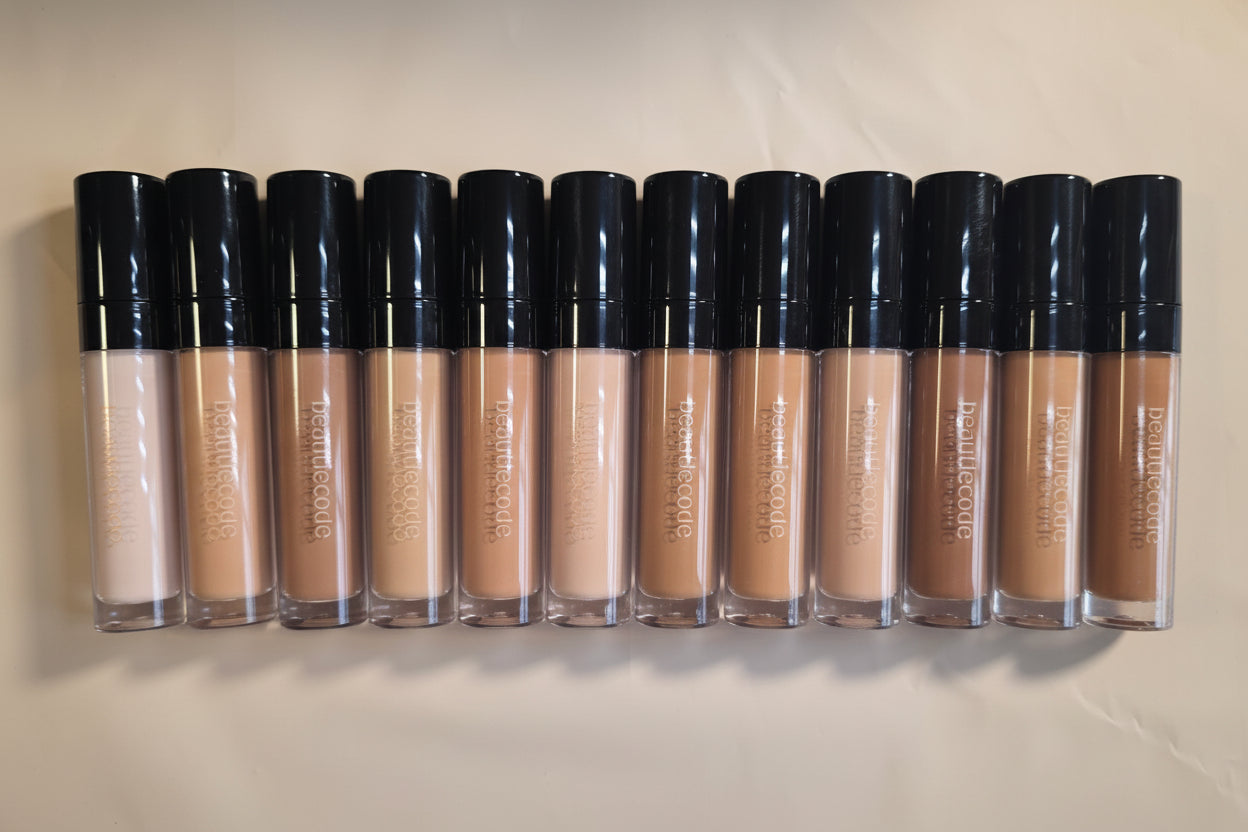 A collection of full coverage concealers in various shades, displayed in individual tubes with the applicator end showing.